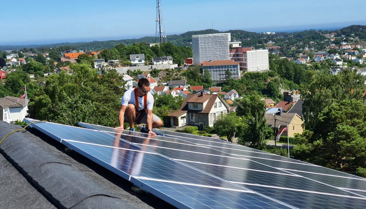 Mann på taket med solpaneler